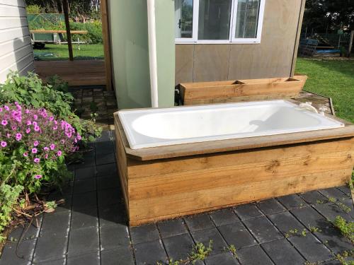 a bath tub sitting outside of a house at @Taradise-Opunake - eco-friendly Coastal hideaway in Opunake