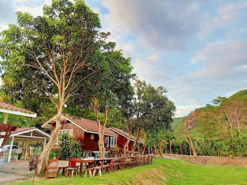 uma casa com mesas e cadeiras em frente em ผาผึ้ง Neverland em Ban Wang Krathon (1)