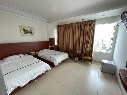Khách Sạn Đông Hải tesisinde bir odada yatak veya yataklar