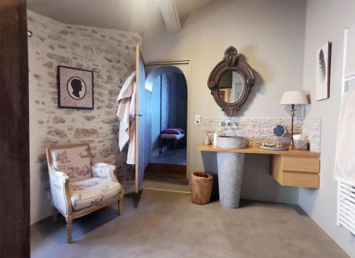 a bathroom with a sink and a mirror and a chair at Le Petit Chateau in Châteauneuf-de-Gadagne