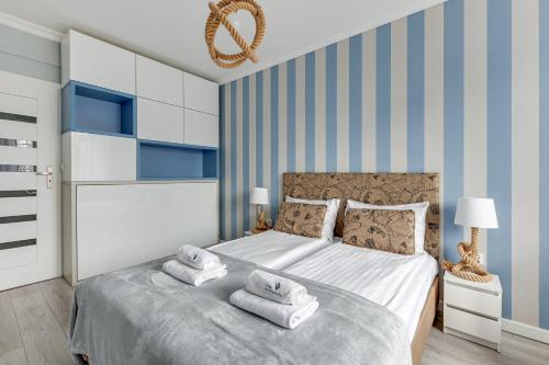 - une chambre avec un lit et des serviettes dans l'établissement Lion Apartments - Bosman I, à Sopot