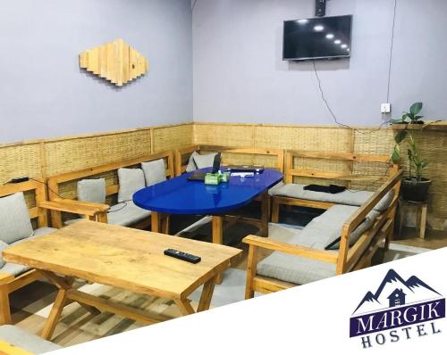 a dining room with a blue table and chairs at Margik Backpackers Hostel in Pokhara