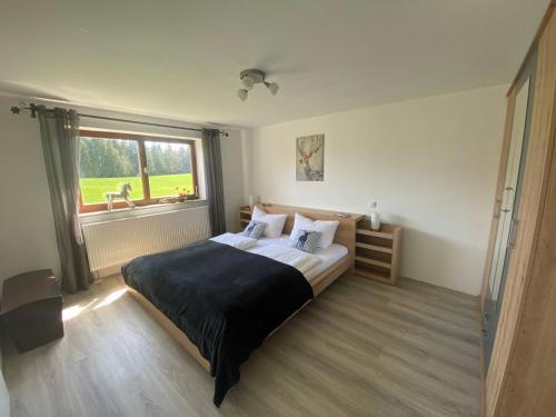 Un dormitorio con una cama grande y una ventana en Ferienhof Steingaden en Steingaden