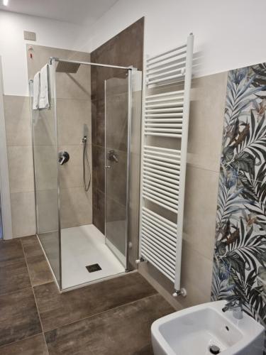 La salle de bains est pourvue d'une douche avec une porte en verre. dans l'établissement Hotel Pace, à Brenzone