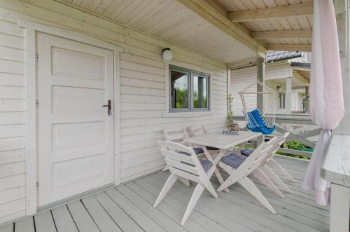 a patio with a table and chairs on a porch at Biale Domki Kopalino in Kopalino