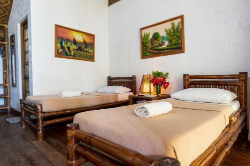 two beds sitting in a room with at Marina Village in Moalboal