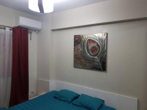 a bedroom with a bed and a painting on the wall at Mucucu's place in Manila
