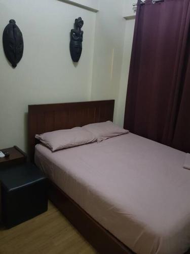 a bedroom with a bed and a nightstand next to it at Mucucu's place in Manila