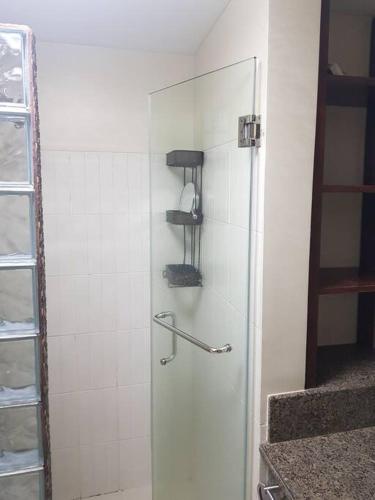 a shower with a glass door in a bathroom at Mucucu's place in Manila