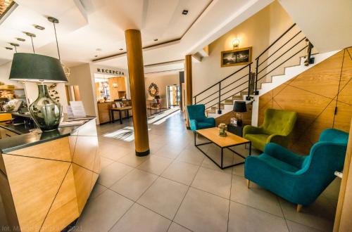 a lobby with blue and green chairs and stairs at Hotel Kompleks Beskid z basenem i stokiem narciarskim - blisko Babiej Góry in Spytkowice