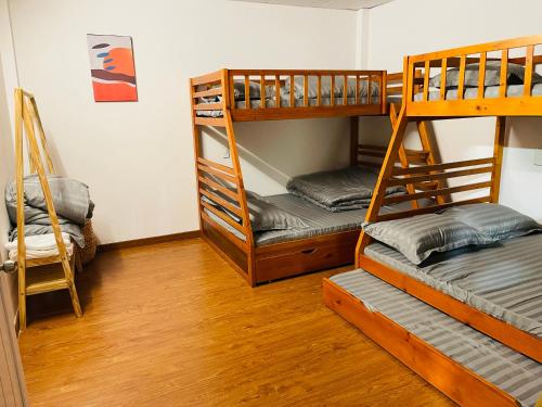 two bunk beds in a room with wooden floors at CT Home in Da Lat