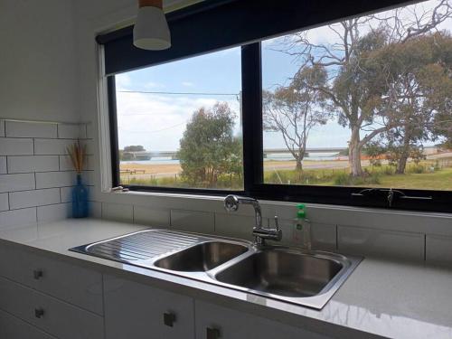 a sink in a kitchen with a window at Bella Blue - Scamander River Stay in Scamander