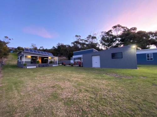 a house with a large yard in front of it at Bella Blue - Scamander River Stay in Scamander