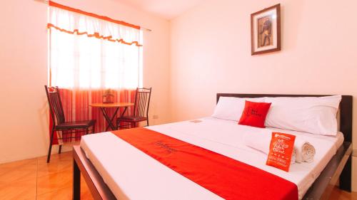 a bedroom with a bed with a red and white blanket at RedDoorz @ FDB Homes Nueva Ecija in Maria Aurora