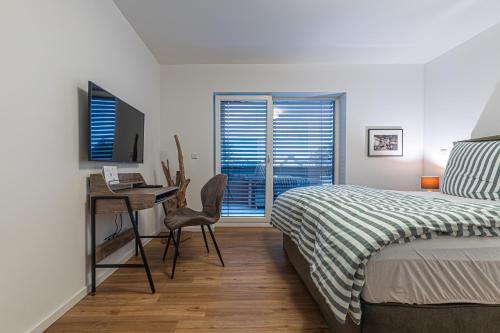 a bedroom with a bed and a desk with a computer at B26 Apartments - Unterwegs zu Hause in Willich