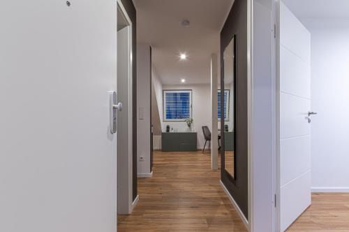 a hallway of a house with white walls and wooden floors at B26 Apartments - Unterwegs zu Hause in Willich