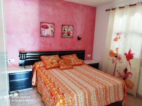 a bedroom with a bed with a red wall at Menorca beach in Cala Galdana