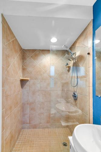 a bathroom with a shower with a toilet and a sink at The Blue Villa - Luxury Clearwater by BlueBellaEstate in Largo