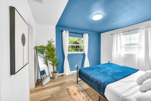 a blue bedroom with a bed and a window at The Blue Villa - Luxury Clearwater by BlueBellaEstate in Largo