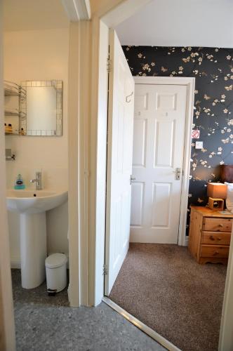 a bathroom with a toilet and a sink and a door at All Seasons Rest in Windermere