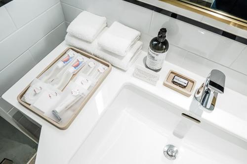 a bathroom sink with a bottle of wine and towels at Montien Hotel Surawong Bangkok in Bangkok