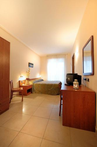 a bedroom with a bed and a television in a room at Hotel Arma Ristorante in Arma di Taggia