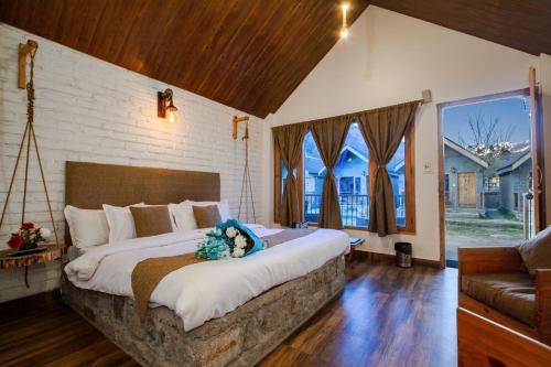 a bedroom with a large bed and a large window at Winterfell The Stay, Unique River Front Resort in Manāli