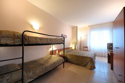 a bedroom with two bunk beds and a television at Hotel Arma Ristorante in Arma di Taggia