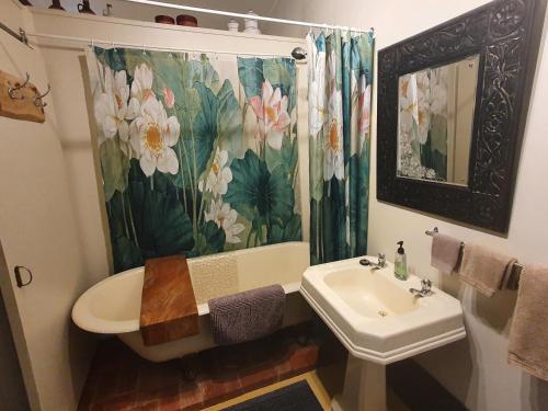 a bathroom with a sink and a shower curtain at Garden Studio in Jaggan