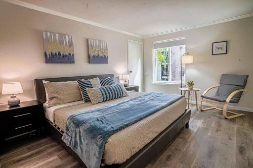 a bedroom with a bed and a chair and a window at Condo with king bed, walk to Microsoft & park in Bellevue