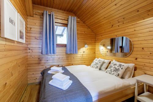 1 dormitorio con 1 cama en una cabaña de madera en Alpinia apartments, en Bled