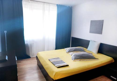 een slaapkamer met een bed met 2 kussens en een raam bij Perla Dorobanti Apartment in Boekarest