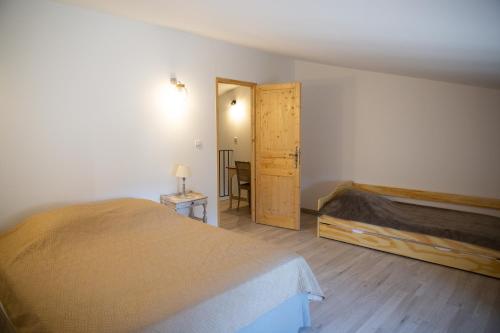 - une chambre avec un lit et une porte en bois dans l'établissement Entre blé et lavande, à Bonnieux