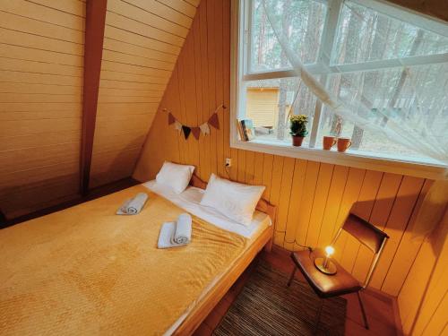 a small bed in a room with a window at Energetikas • nameliai prie jūros in Šventoji