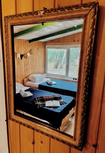 a mirror reflection of a bed in a room at Energetikas • nameliai prie jūros in Šventoji