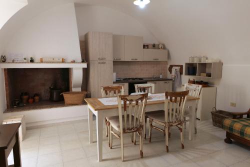 uma cozinha com mesa e cadeiras num quarto em CASA FIORE em Corigliano dʼOtranto