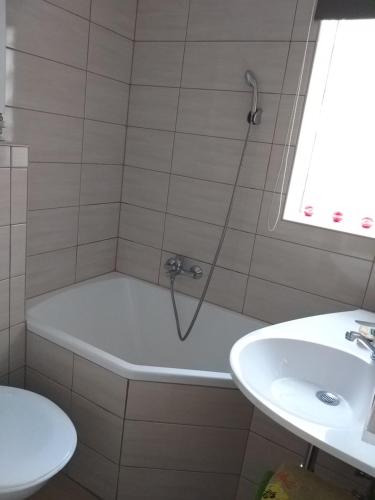 La salle de bains est pourvue d'une baignoire et d'un lavabo. dans l'établissement Nefelejcs Nyaraló-Vendégház, à Dunasziget