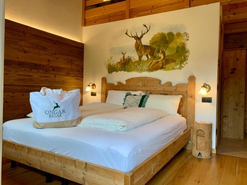 a bedroom with a bed with a deer picture on the wall at Ongar Relax b&b in Bosco Chiesanuova