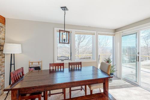 a dining room with a table and chairs and windows at South Village #49 in Warren
