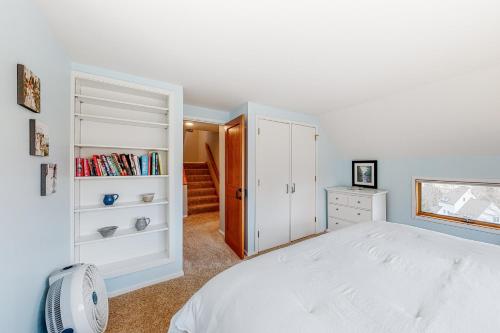 a white bedroom with a bed and a closet at South Village #49 in Warren