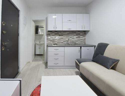 ein Wohnzimmer mit einem Sofa und einer Küche in der Unterkunft Elem apartmani in Tuzla