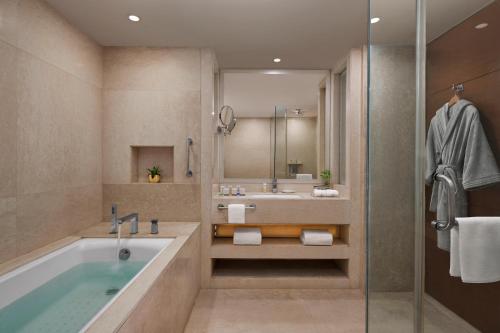 y baño con bañera y lavamanos. en Hyatt Centric Janakpuri New Delhi, en Nueva Delhi
