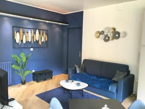 a living room with a blue couch and a table at Domaine La Castilha in Biscarrosse