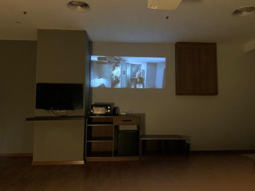 una stanza con una tv e una scrivania con un bancone sidx sidx sidx di The Luxmi - Bangsar Trade Centre a Kuala Lumpur