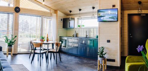 een keuken en eetkamer met een tafel en een fornuis bij Holiday Houses LILLE`S with sauna in Alūksne
