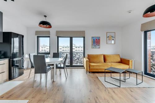 a living room with a table and a couch at Dwie Motławy Apartinfo Apartments in Gdańsk