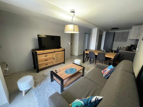 a living room with a couch and a tv and a table at ARC 1800 Appartement 6-8 pers,5 cristaux, avec garage in Arc 1800