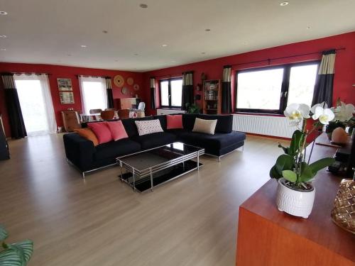 ein Wohnzimmer mit einem Sofa und einem Tisch in der Unterkunft La roche trouée - Maison avec vue à Nismes in Nismes