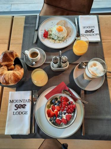 a table with plates of breakfast food and a bowl of fruit at Mountain See Lodge in See