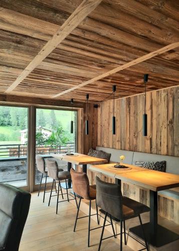 a dining room with wooden ceilings and tables and chairs at Mountain See Lodge in See